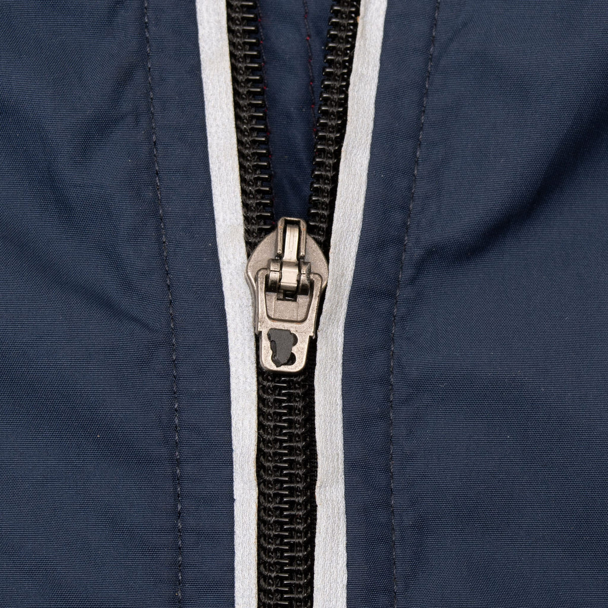 Close-up of the Nike windbreaker's black front zipper with white trim