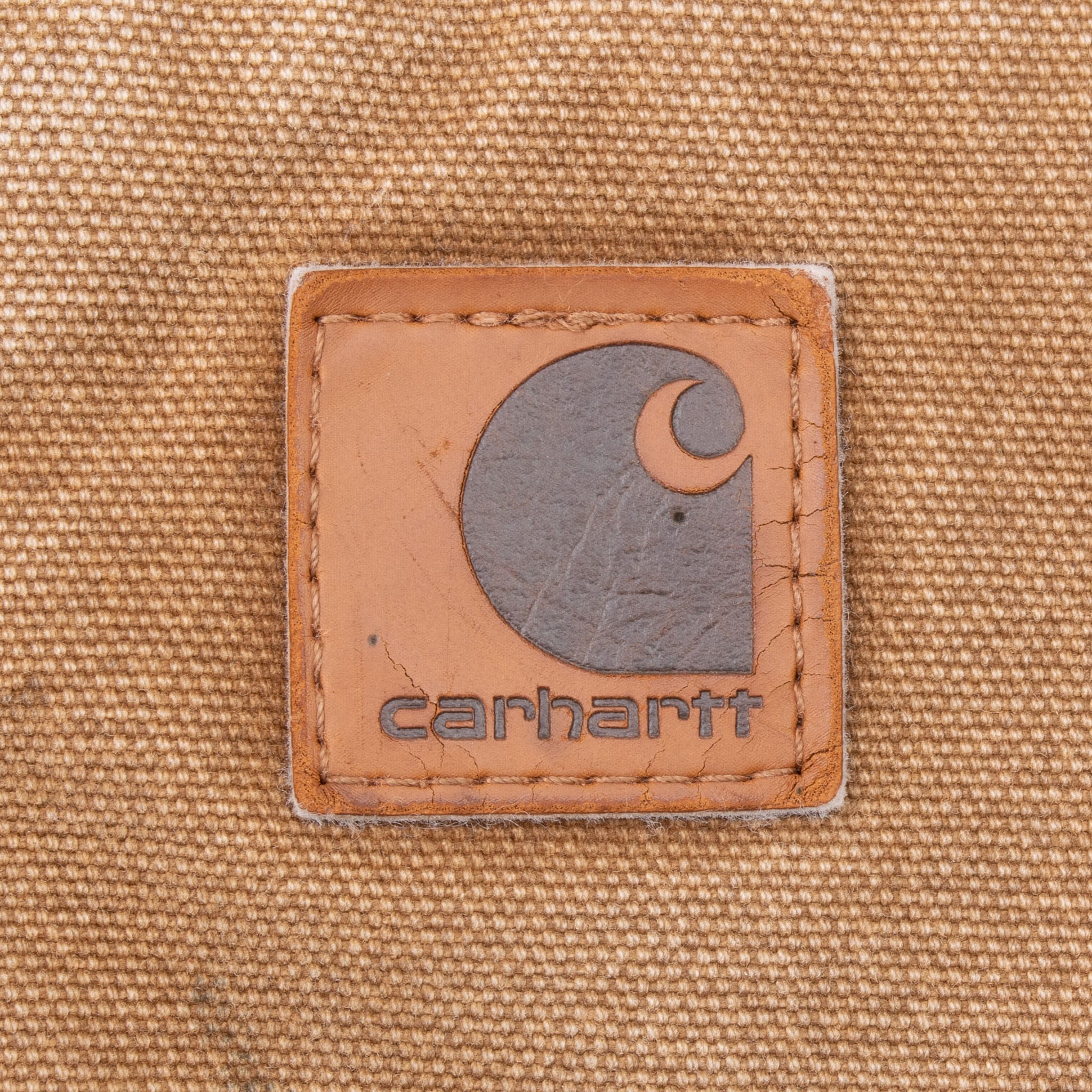 Close-up of Carhartt logo patch on brown vest pocket