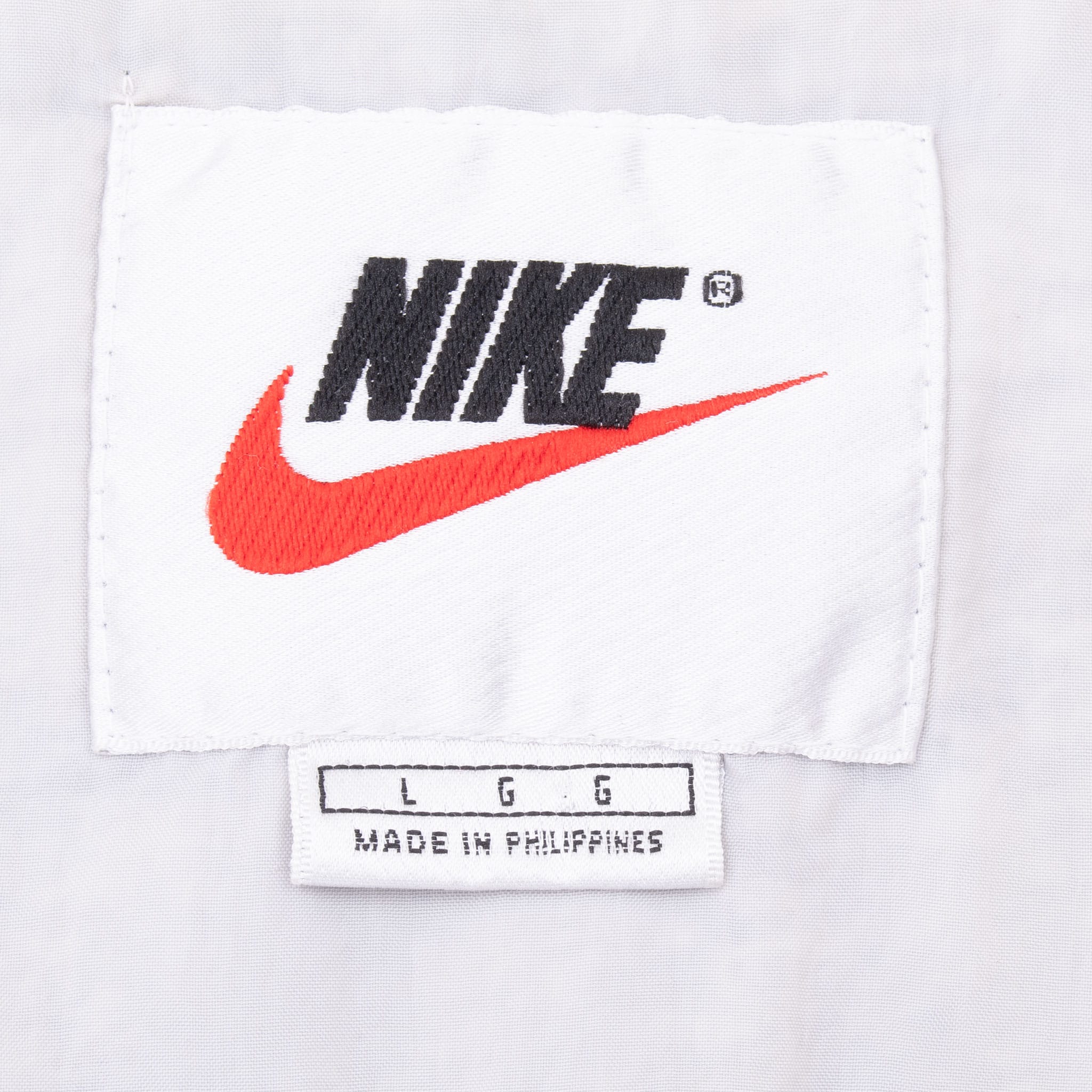 Nike neck label with black spellout, red Swoosh and large size tag