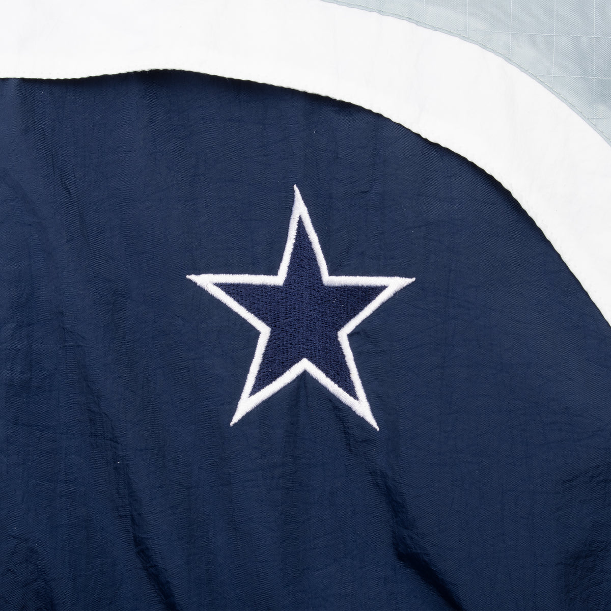 Close-up of embroidered Dallas Cowboys star on navy jacket fabric