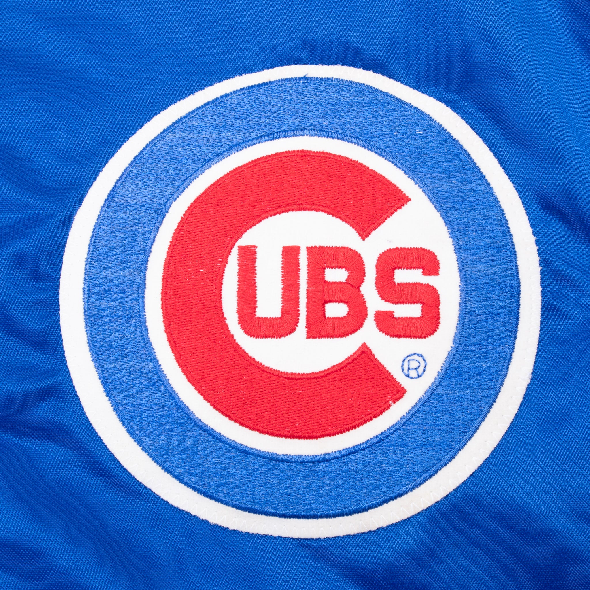 Close-up of embroidered Chicago Cubs logo on blue jacket chest