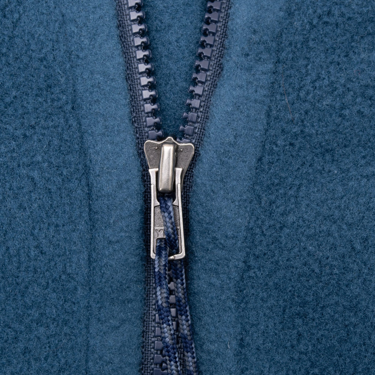 Close-up of front zipper and cord pull on blue Patagonia fleece