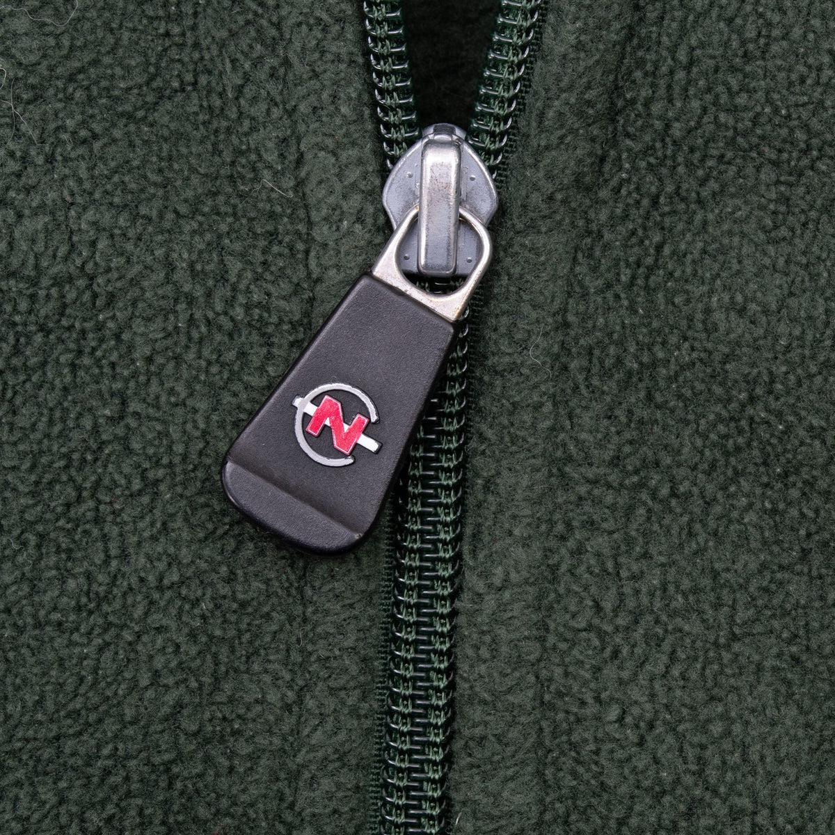 Close-up of Nautica Competition logo zipper pull on green fleece