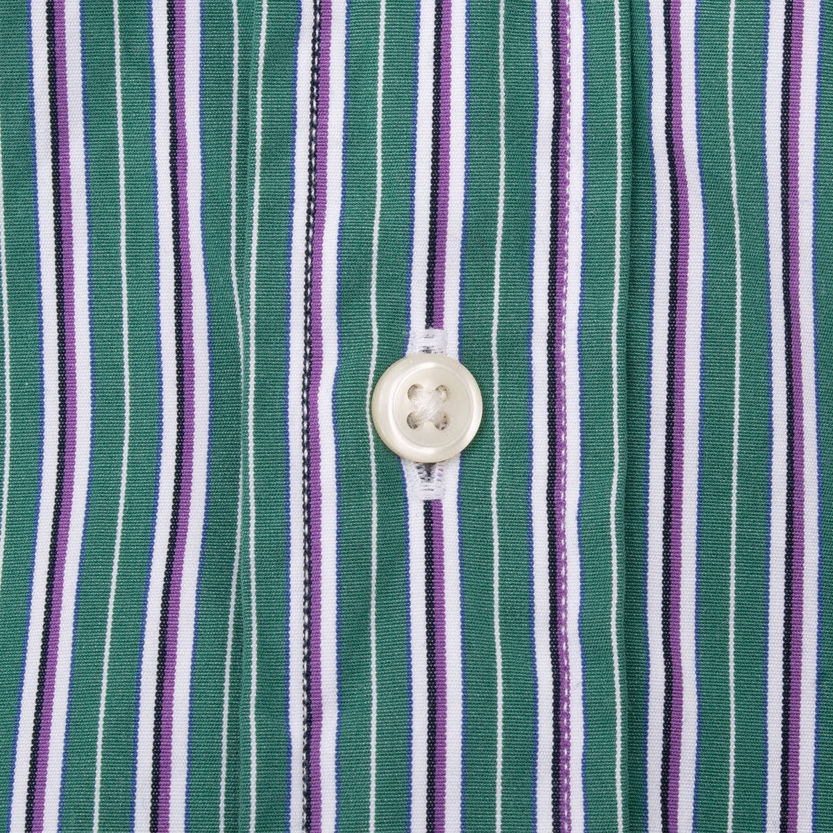 White front button detail on green, white, and purple striped fabric