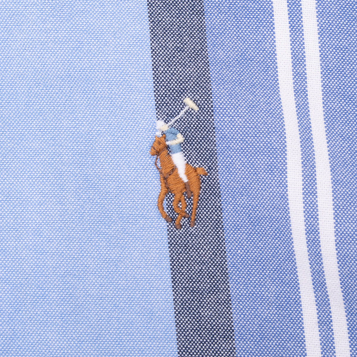 Close-up of Ralph Lauren pony embroidery on blue striped fabric
