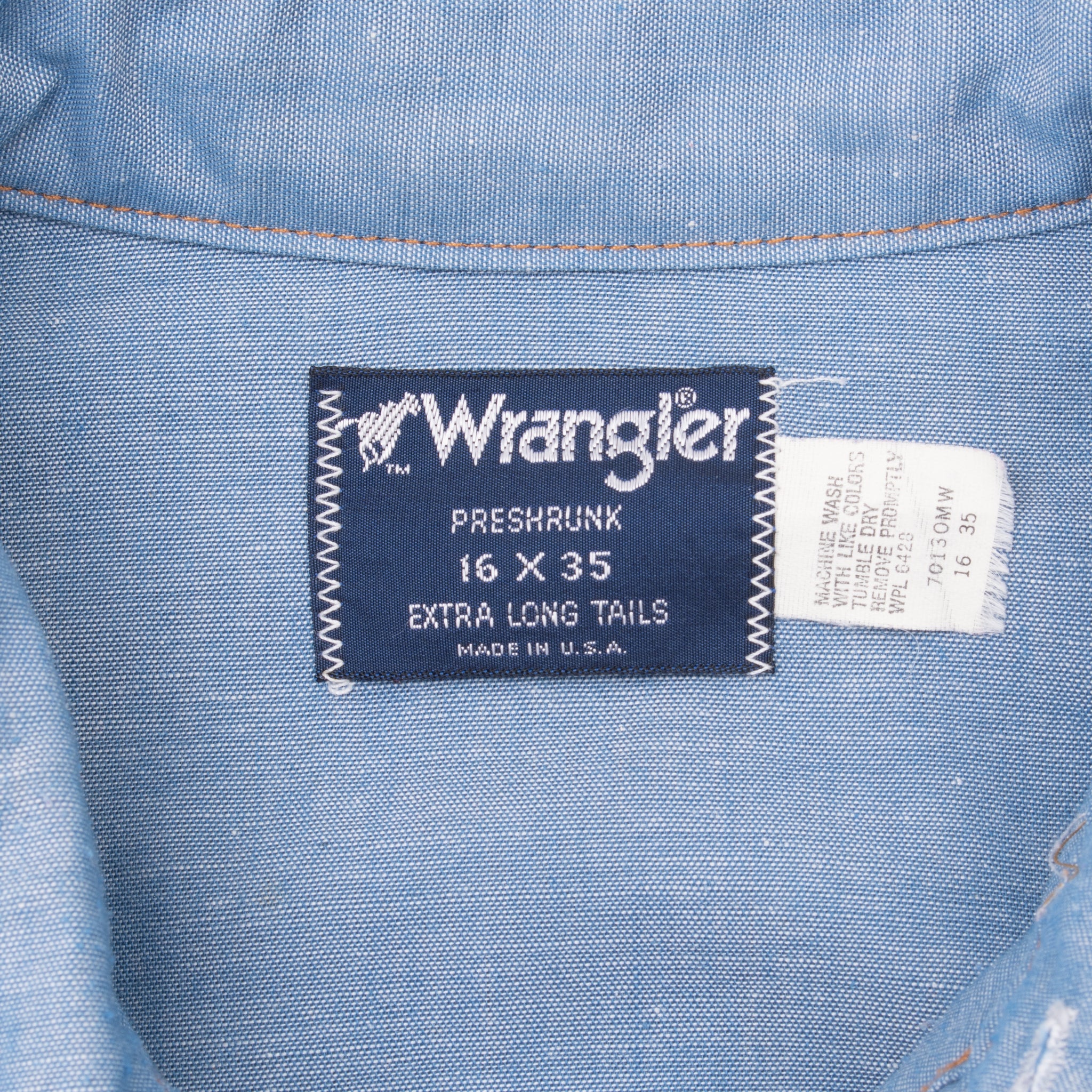 Wrangler collar label and care tag on blue chambray shirt