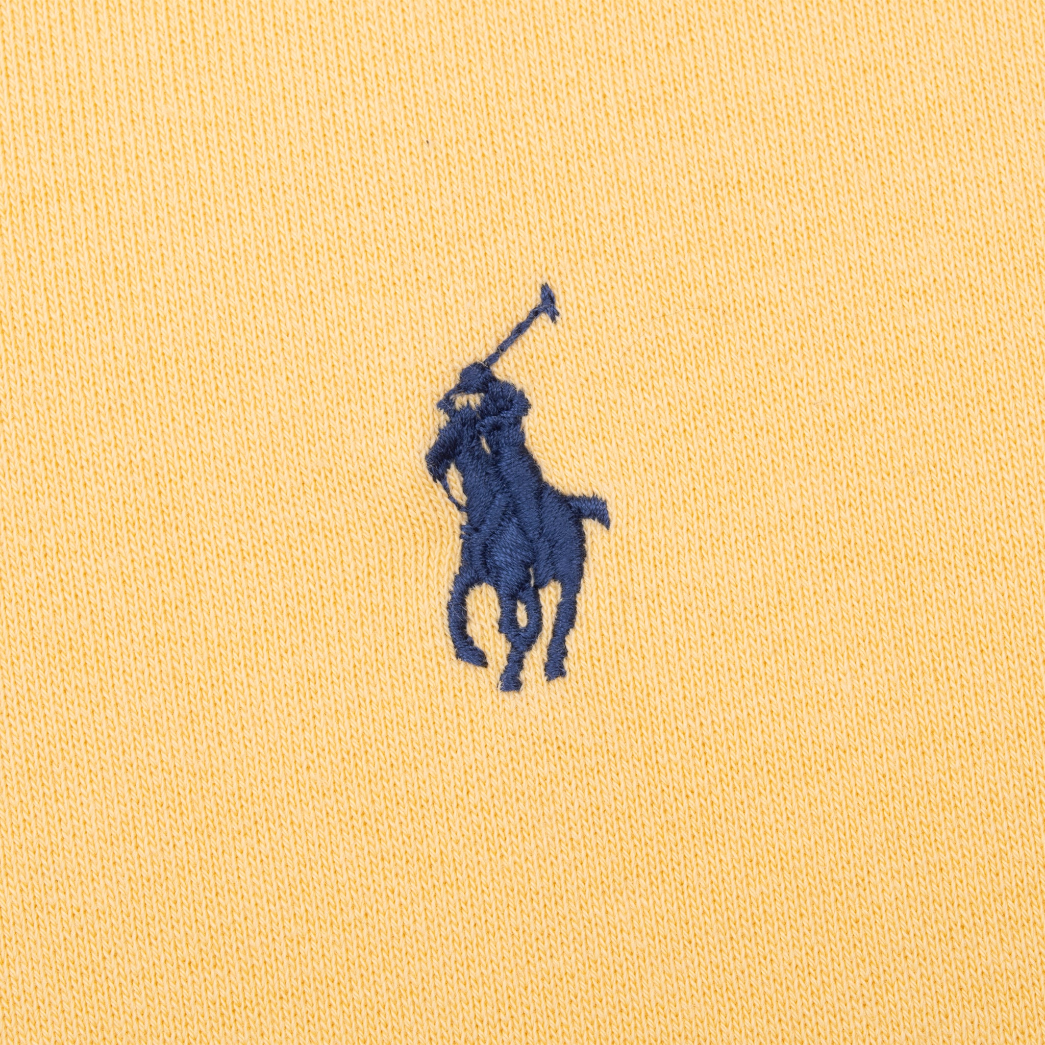 Close-up of navy Polo pony embroidery on yellow sweatshirt