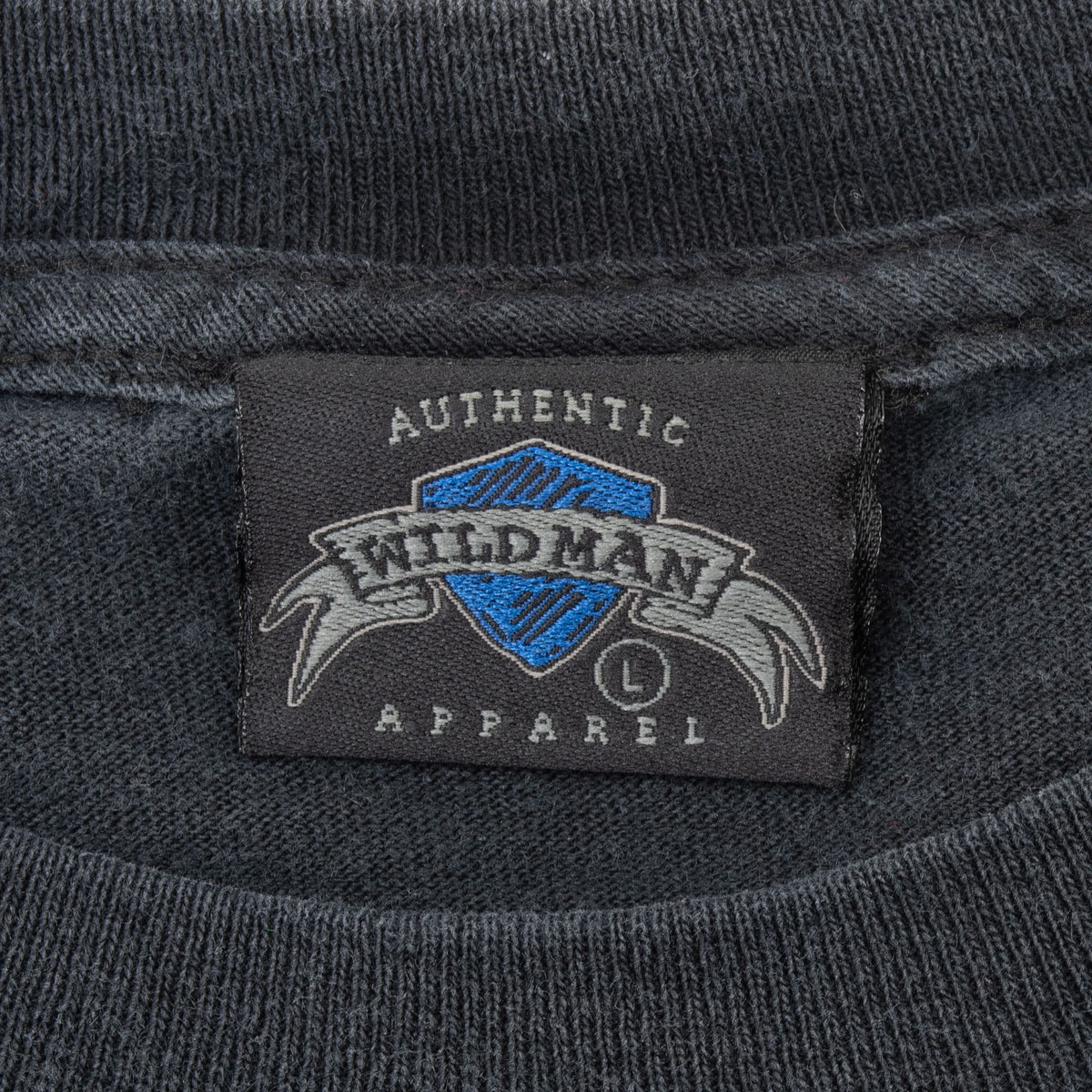 Close-up of M&O Knits Apparel size large neck tag on black T-shirt