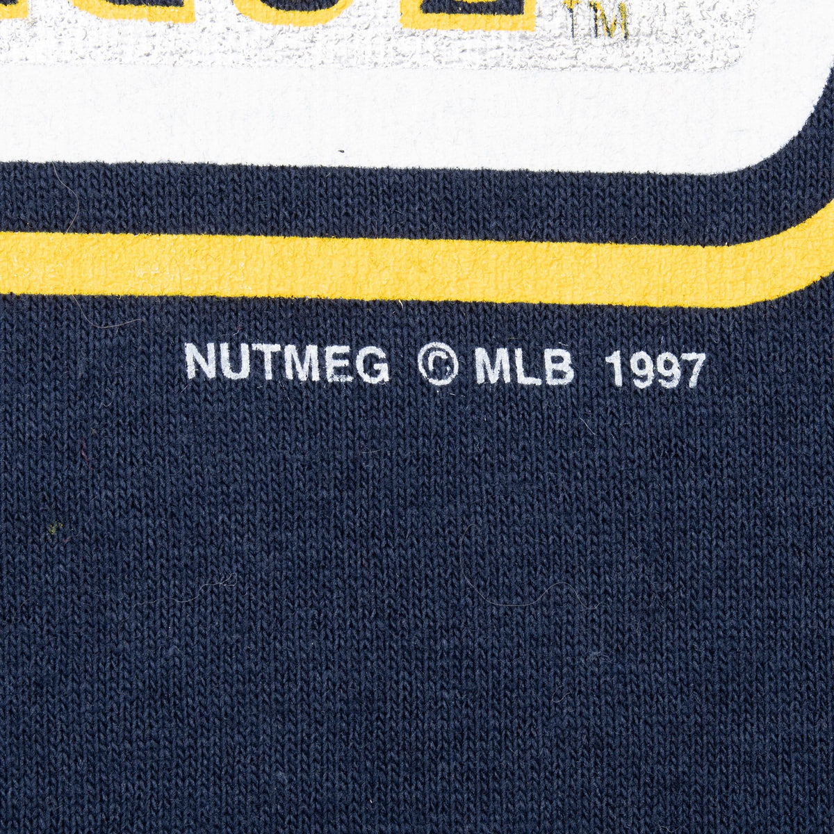 Close-up of Nutmeg MLB 1997 copyright mark beneath the front print