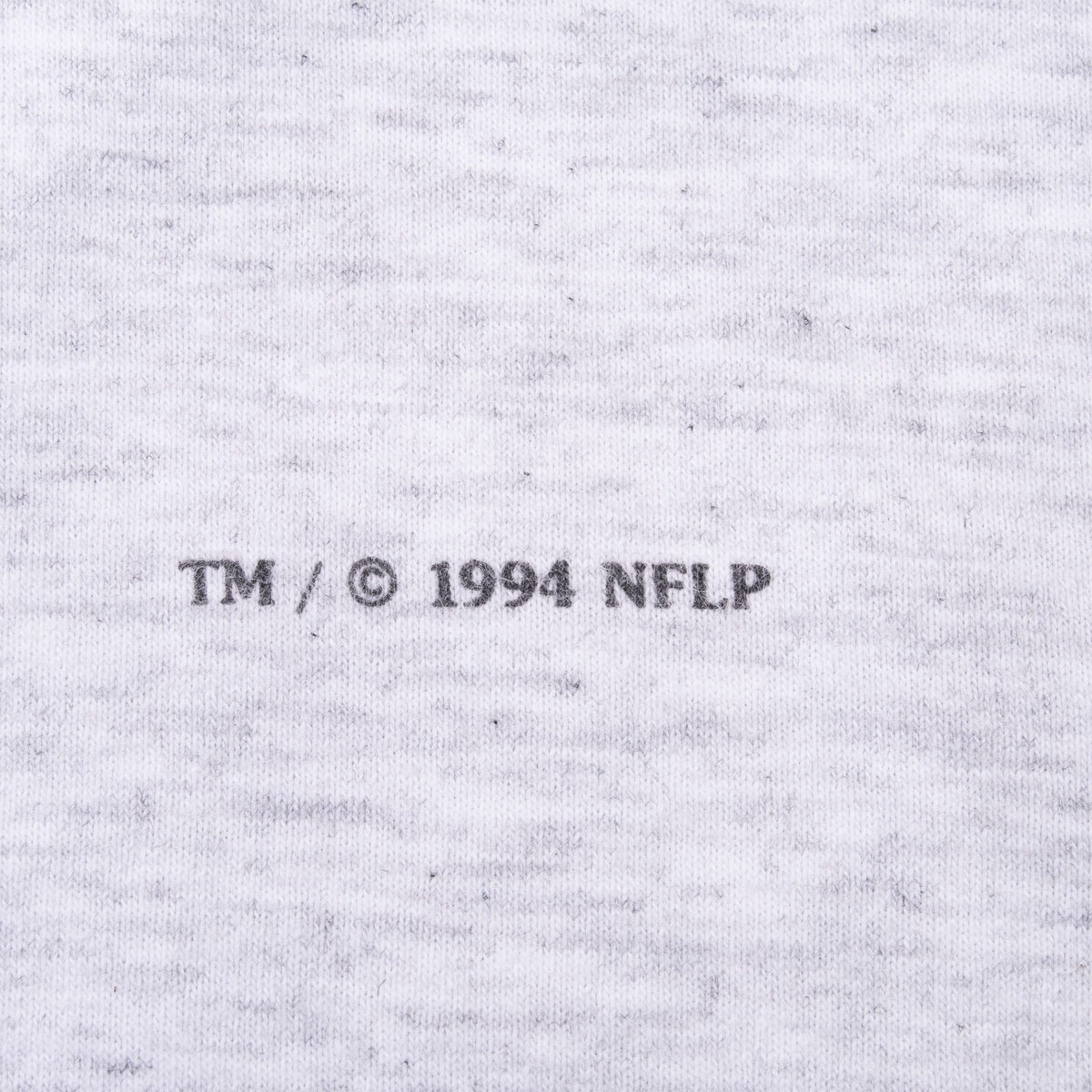 Close-up of TM and 1994 NFLP copyright text printed on gray fabric