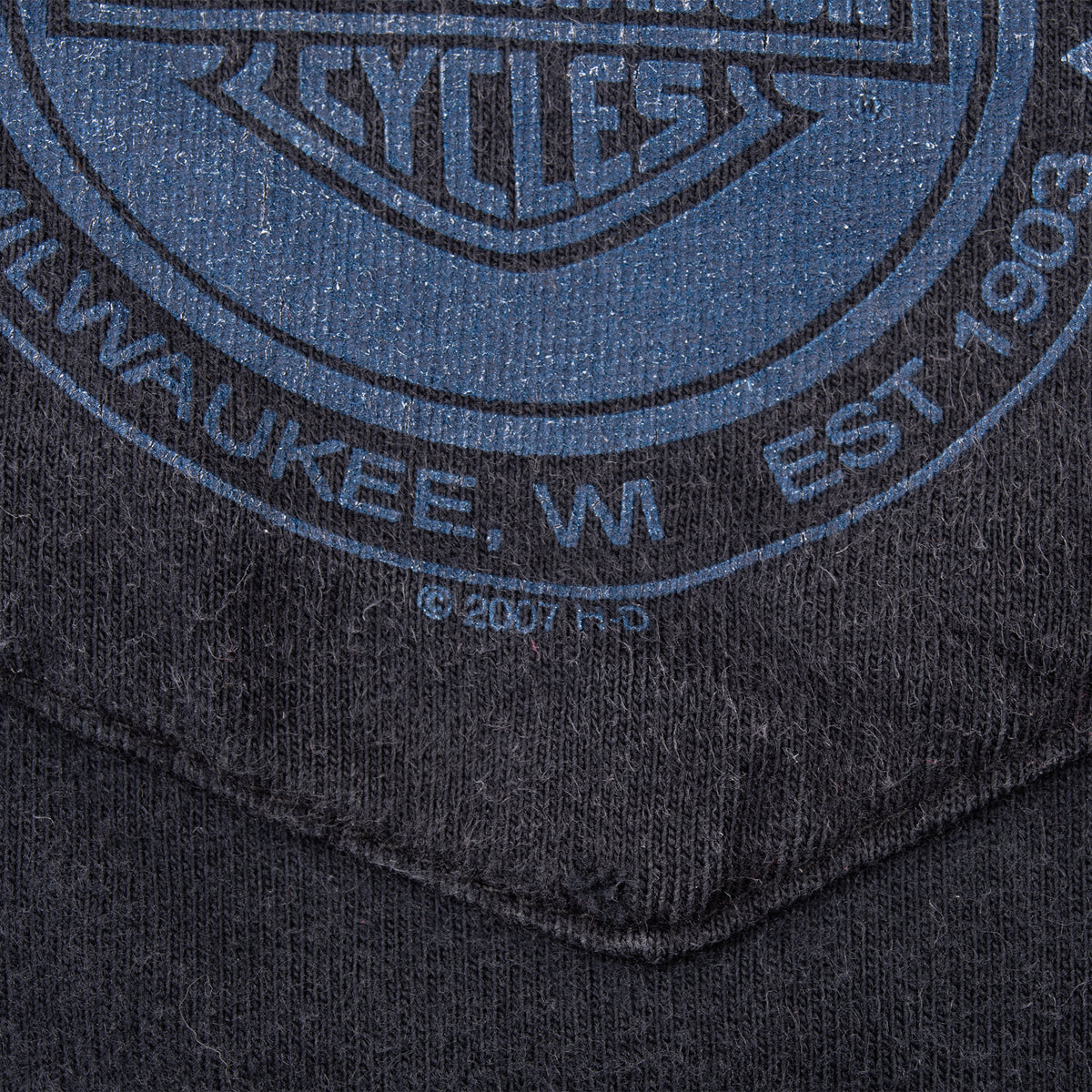 Close-up of blue Harley-Davidson Milwaukee logo print and 2007 mark on chest pocket