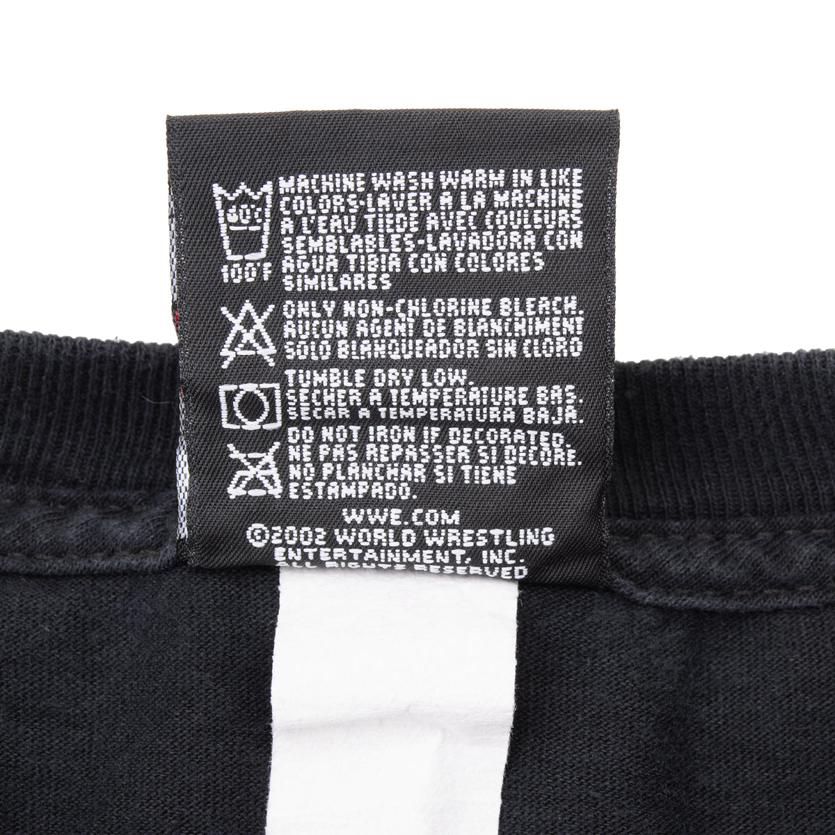 WWE T-shirt care label with washing instructions and 2002 copyright text