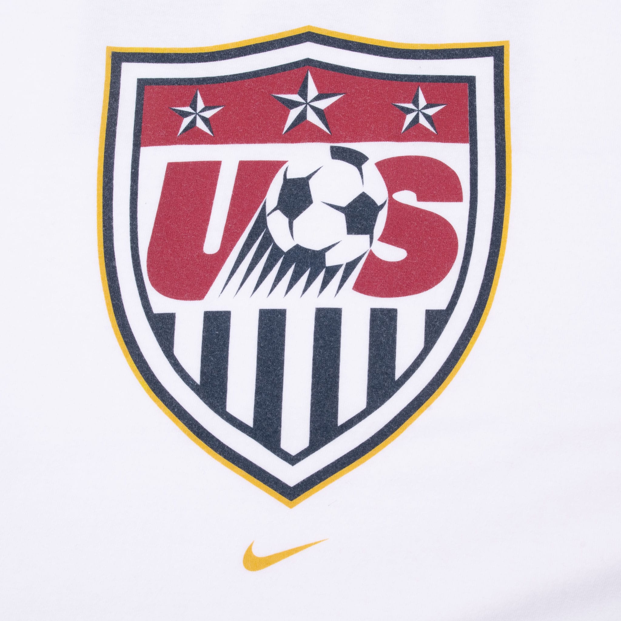 Close-up of red, navy and gold USA soccer crest print with gold Nike Swoosh