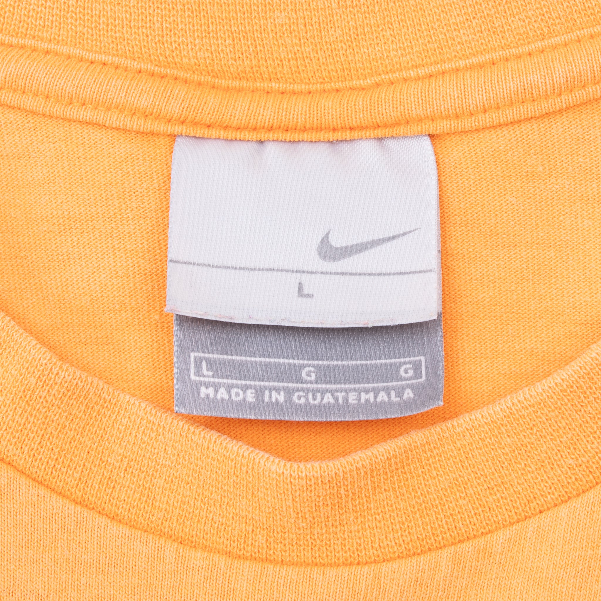 Close-up of Nike neck tag marked size large inside orange T-shirt
