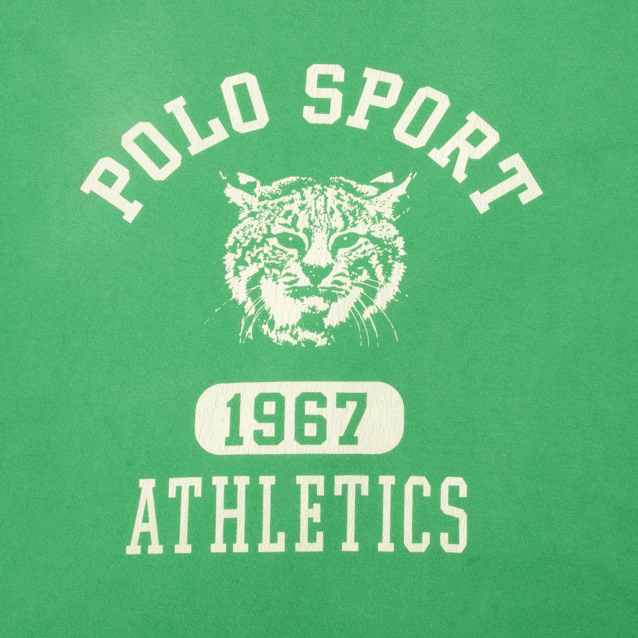 Close-up of white Polo Sport 1967 Athletics tiger print on green fabric