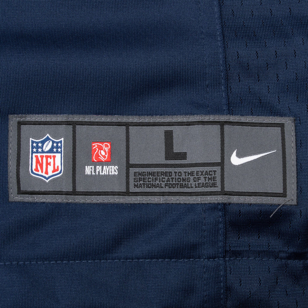 Close-up of Nike NFL and NFL Players branded hem patch on navy jersey