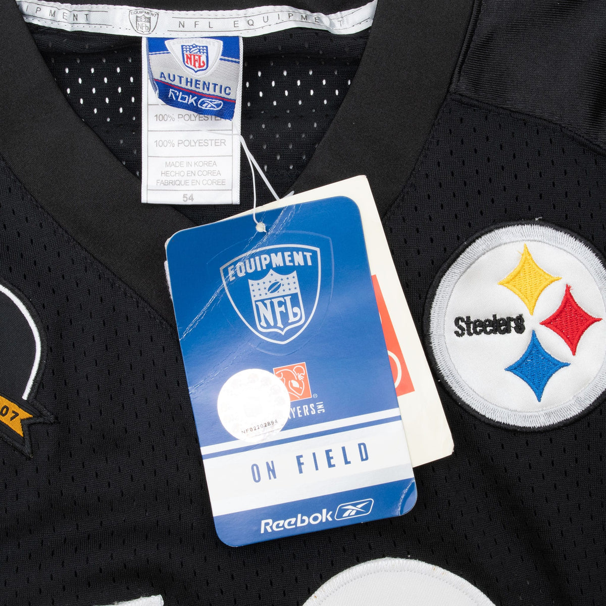Reebok neck label and hangtags beside the embroidered Pittsburgh Steelers chest logo