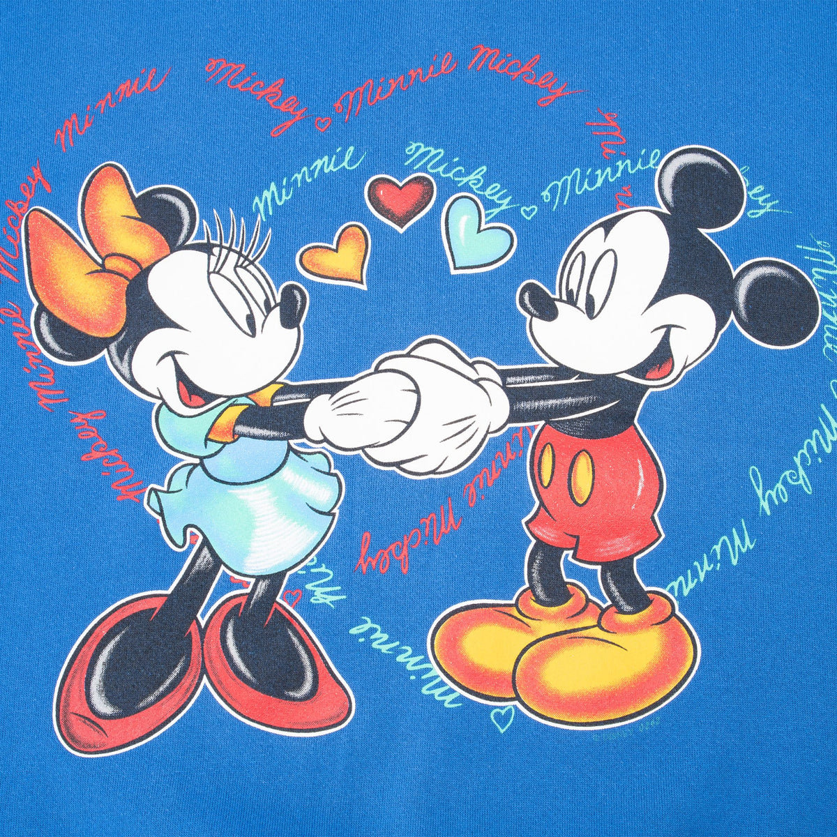 Close-up of Mickey and Minnie Mouse holding hands with colorful hearts and script names
