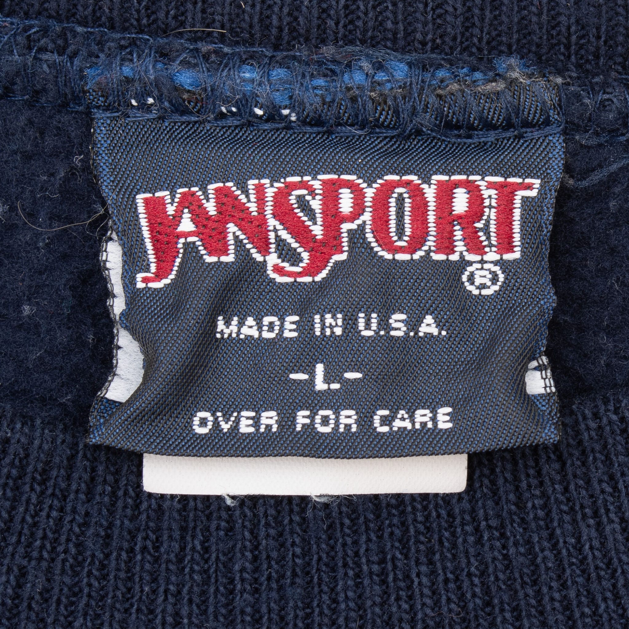 JanSport neck tag marked Made in U.S.A., size L, and Over for Care