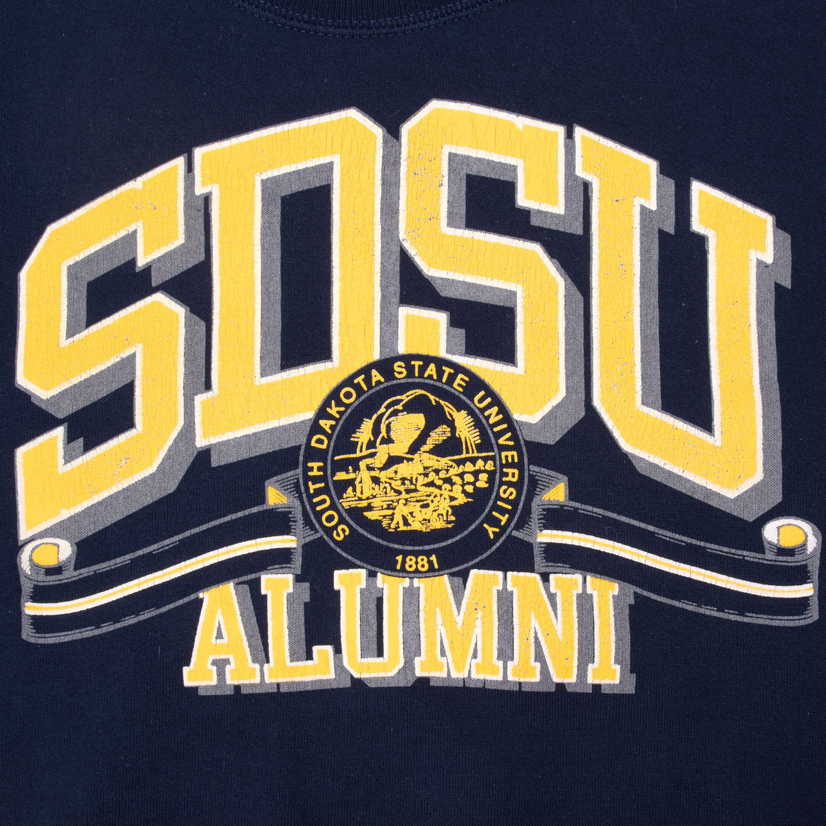 Close-up of yellow, white and gray SDSU Alumni print with South Dakota State University 1881 seal