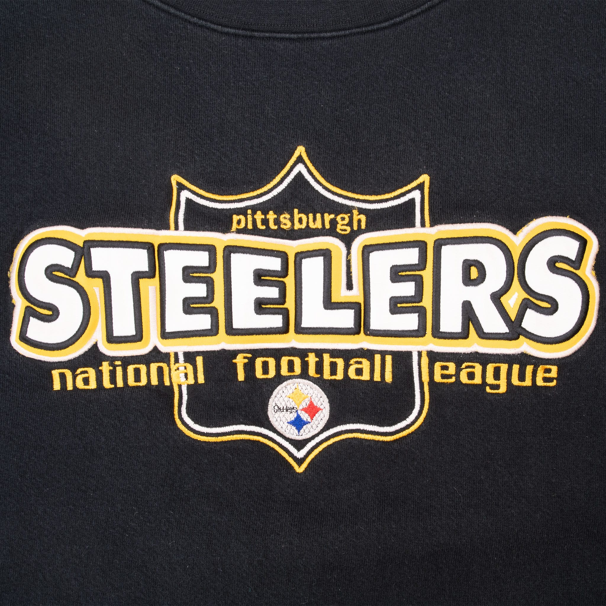 Close-up of embroidered Pittsburgh Steelers shield lettering and team logo