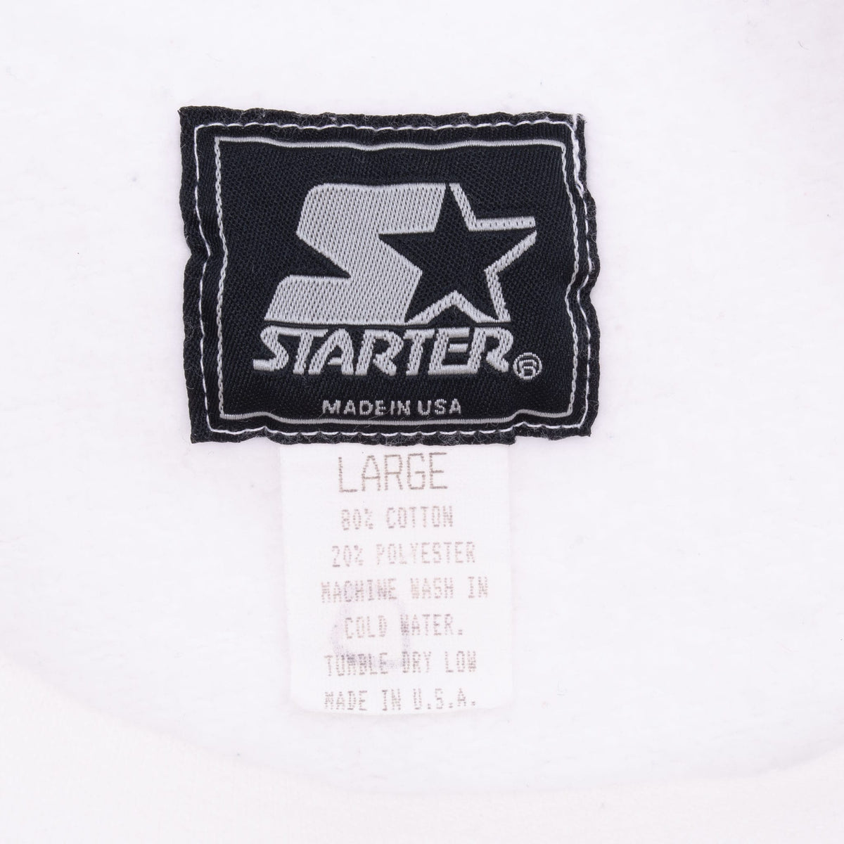 Starter neck tag showing size large, fabric blend, care instructions, and Made in USA text
