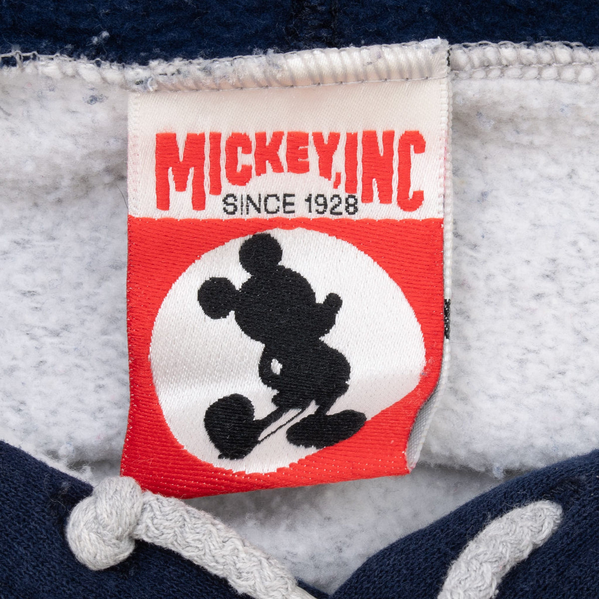 Mickey Inc neck label with Mickey Mouse silhouette and Since 1928 text
