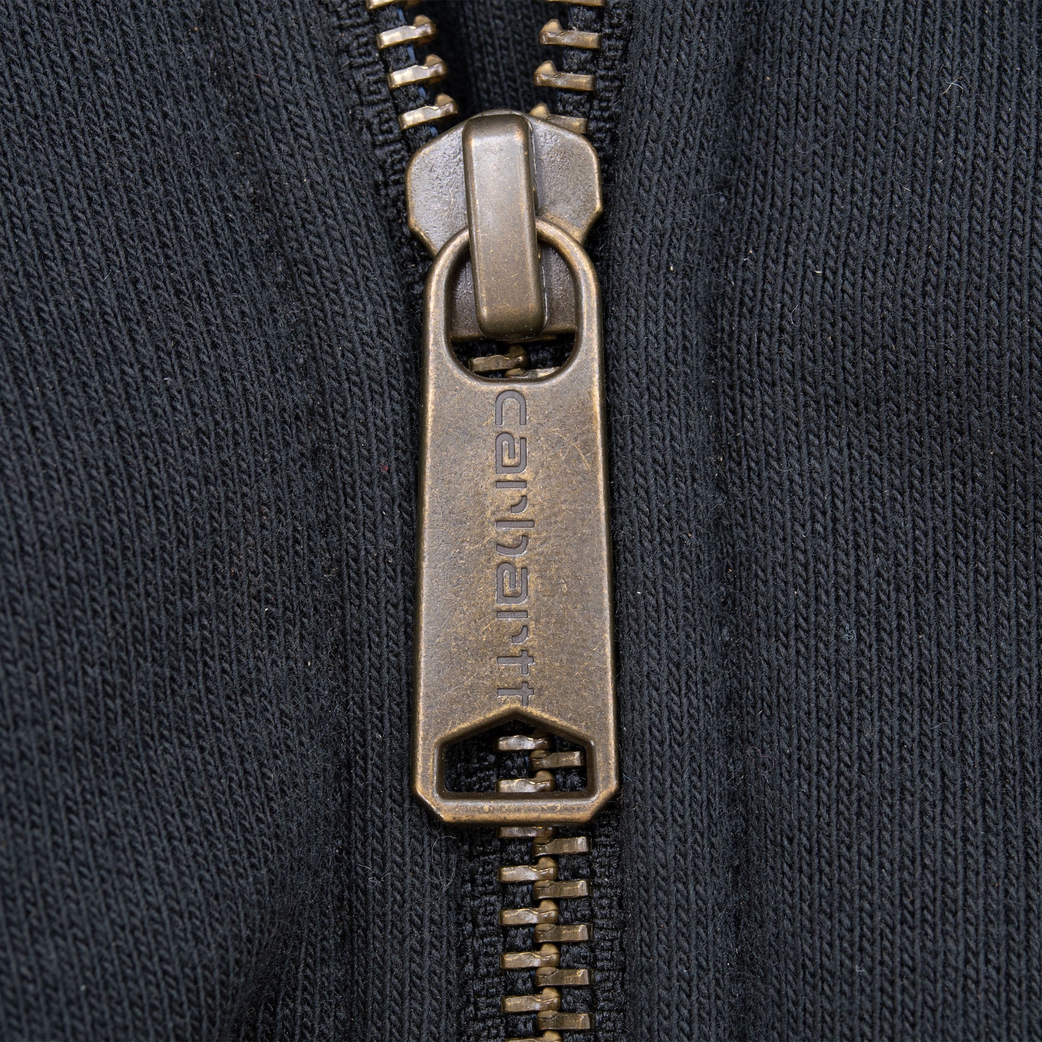 Close-up of Carhartt-branded metal zipper pull on black hoodie