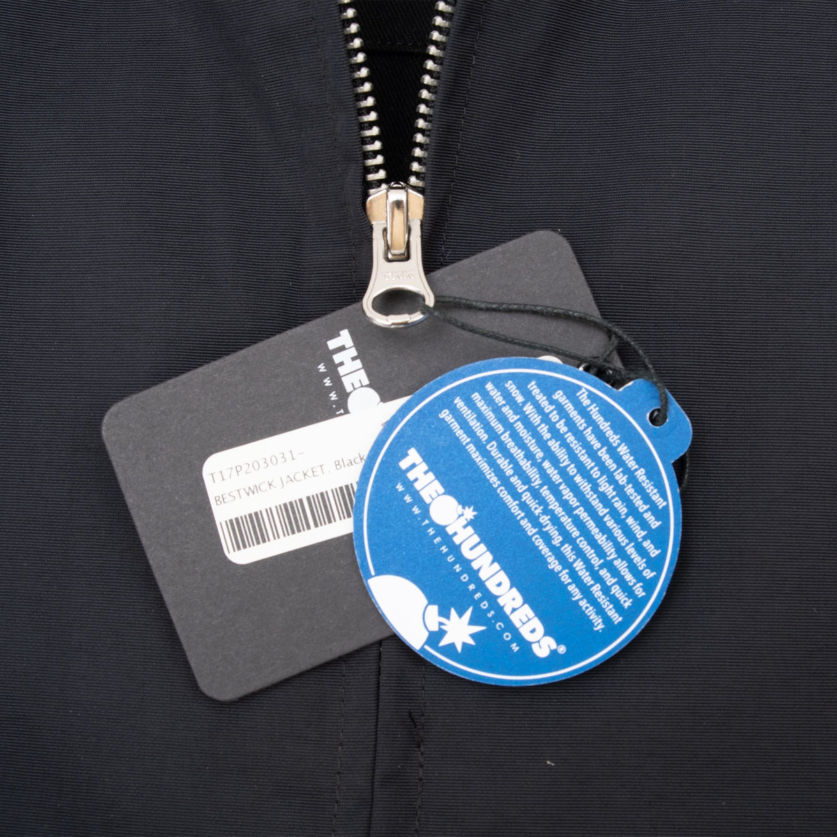 The Hundreds black and blue hangtags attached beside the jacket's front zipper