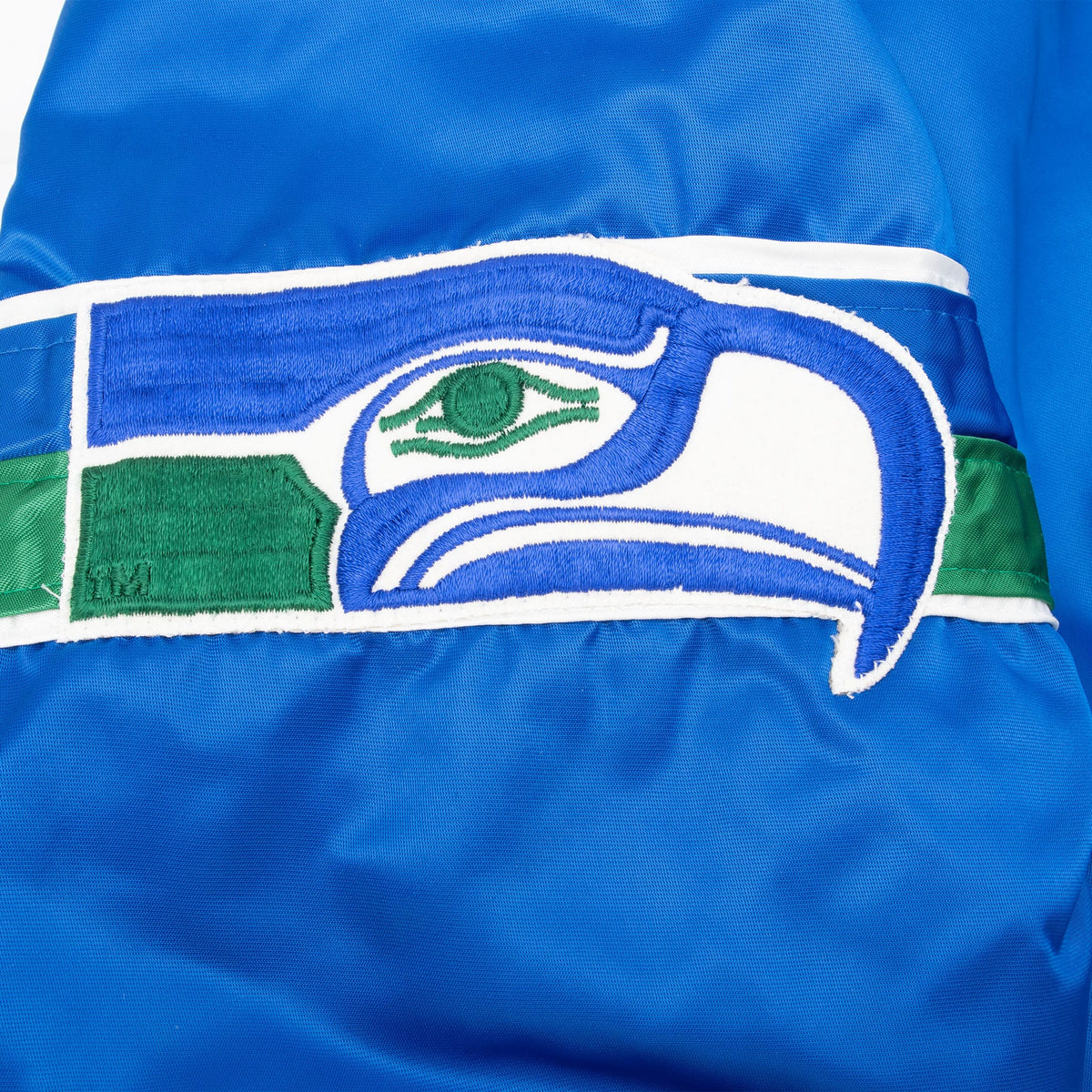 Close-up of embroidered Seattle Seahawks logo band on blue sleeve