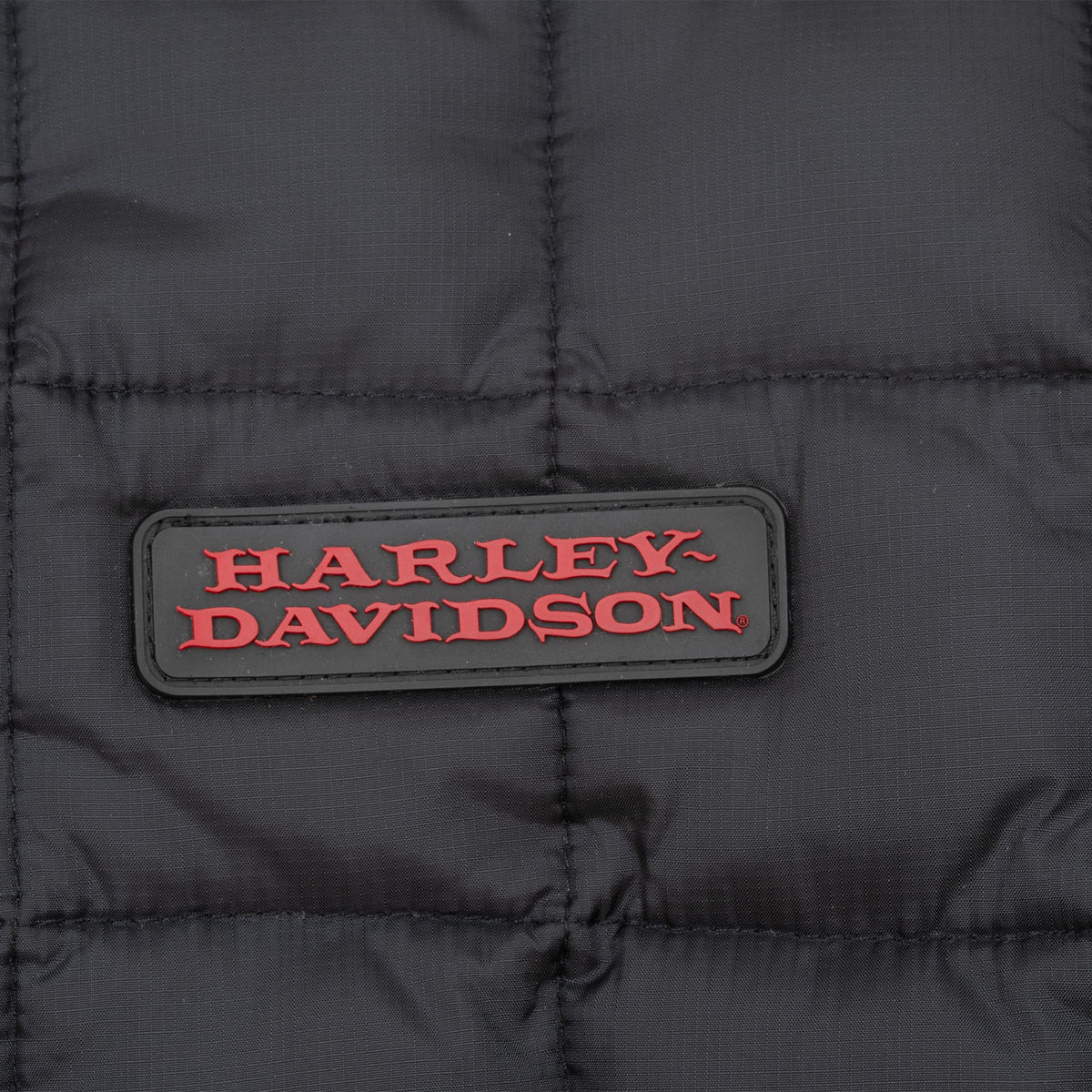 Close-up of red Harley-Davidson chest patch on black quilted fabric