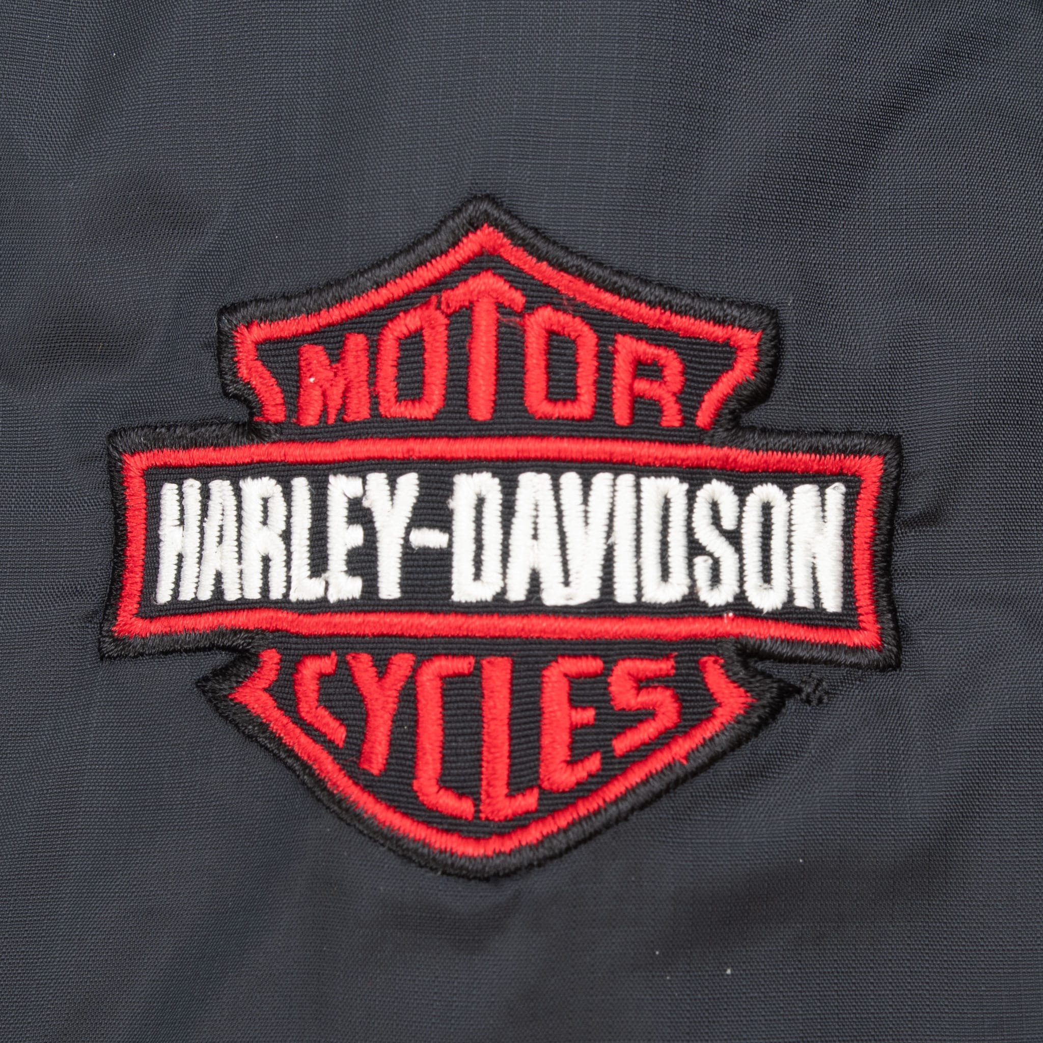 Close-up of red, white, and black Harley-Davidson Bar & Shield sleeve patch