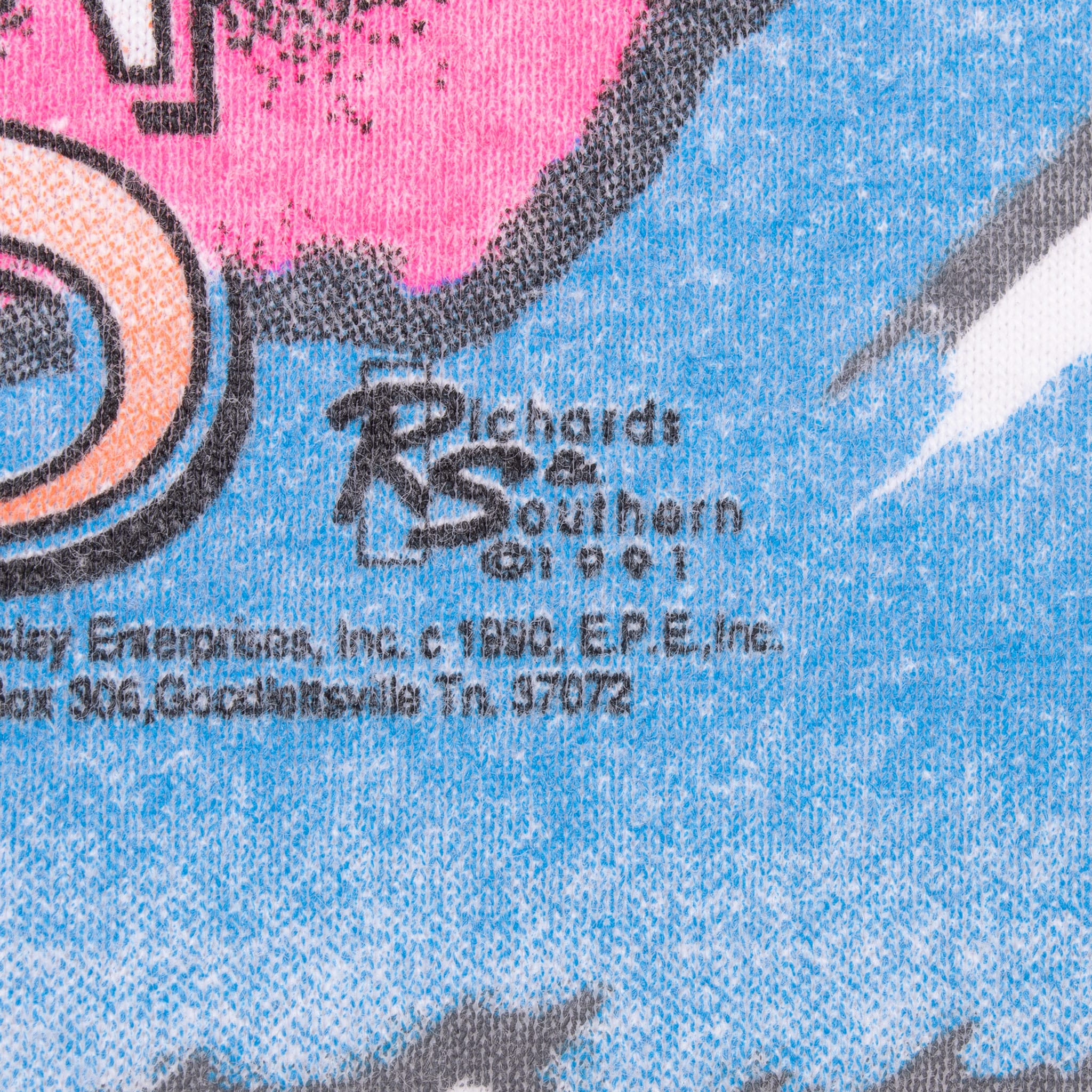 Close-up of artist signature and 1991 copyright text printed on the blue portion of the Elvis graphic