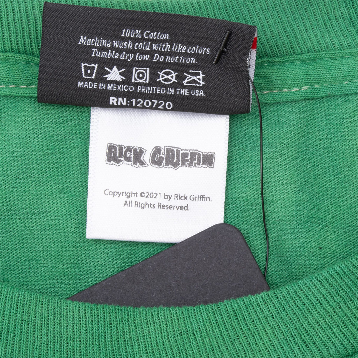 Close-up of cotton care label and Rick Griffin copyright 2021 tag inside shirt