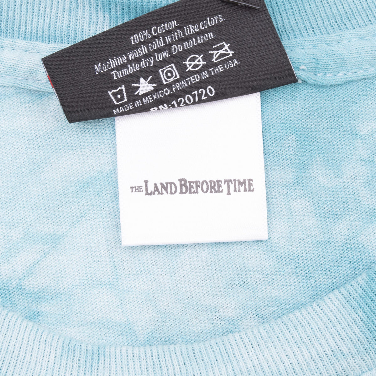 Close-up of care label and The Land Before Time collaboration tag inside the neckline