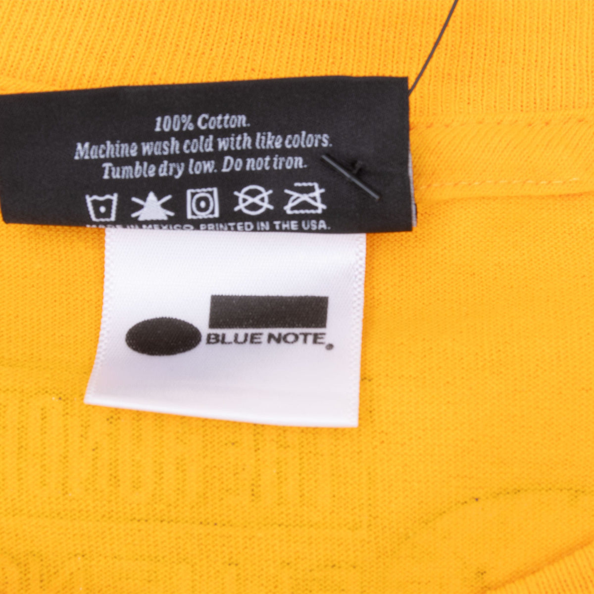 Close-up of Blue Note label and printed care tag inside the yellow T-shirt