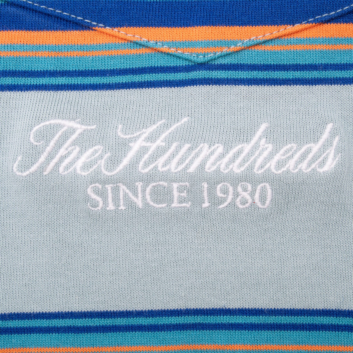 Close-up of white The Hundreds Since 1980 embroidery below the striped chest pocket