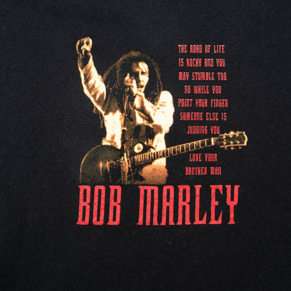 Close-up of front chest print showing Bob Marley with guitar, quote and red name lettering