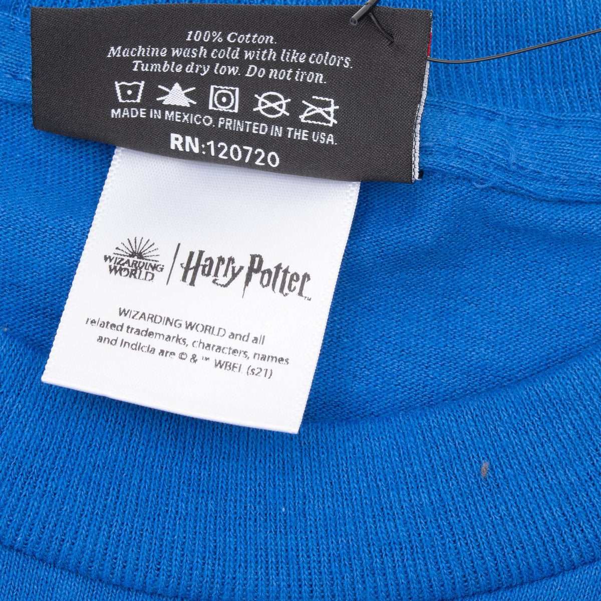 Close-up of care label and Wizarding World Harry Potter licensing label inside blue T-shirt