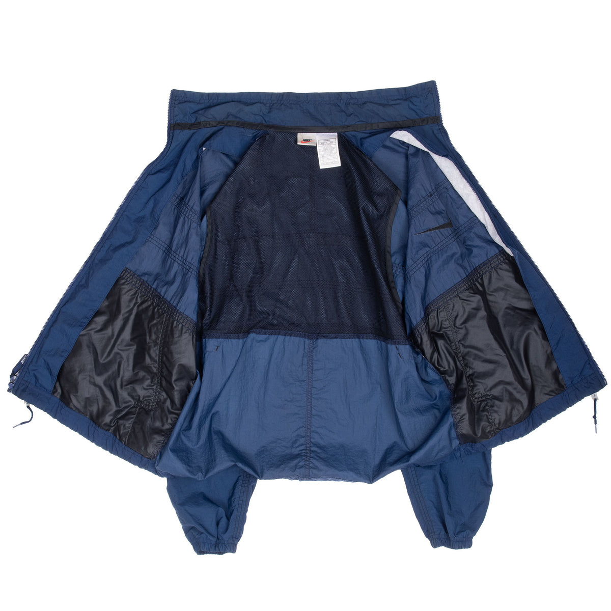 Interior of blue Nike windbreaker opened to show dark mesh lining and labels