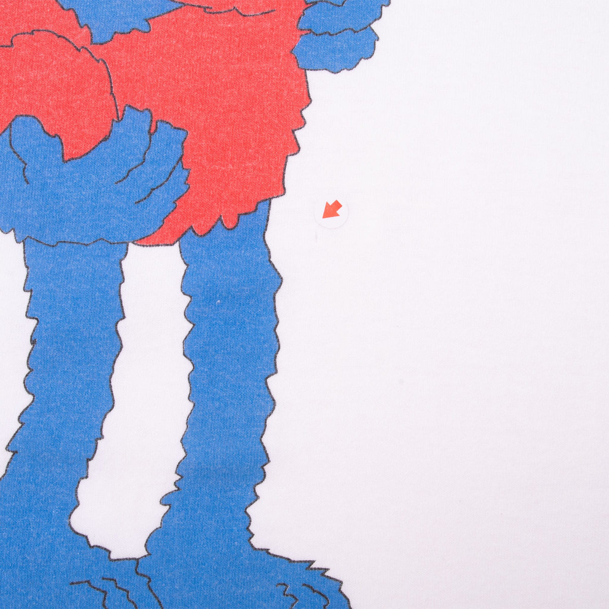 Close-up of Grover and Elmo print with arrow indicating a small mark on the white fabric