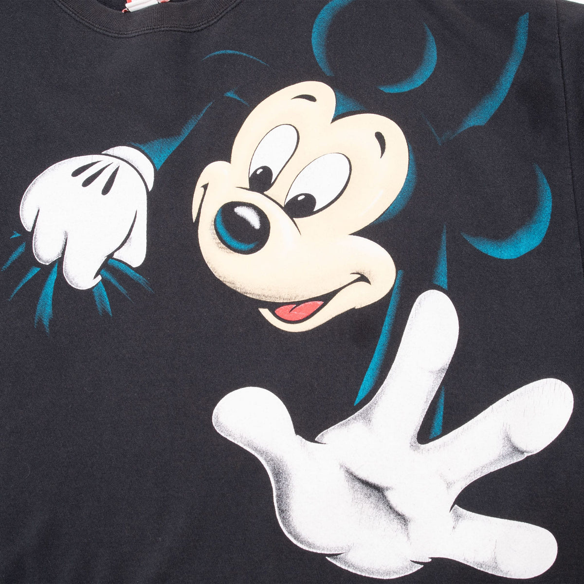 Close-up of Mickey Mouse face and white gloves on front of black sweatshirt