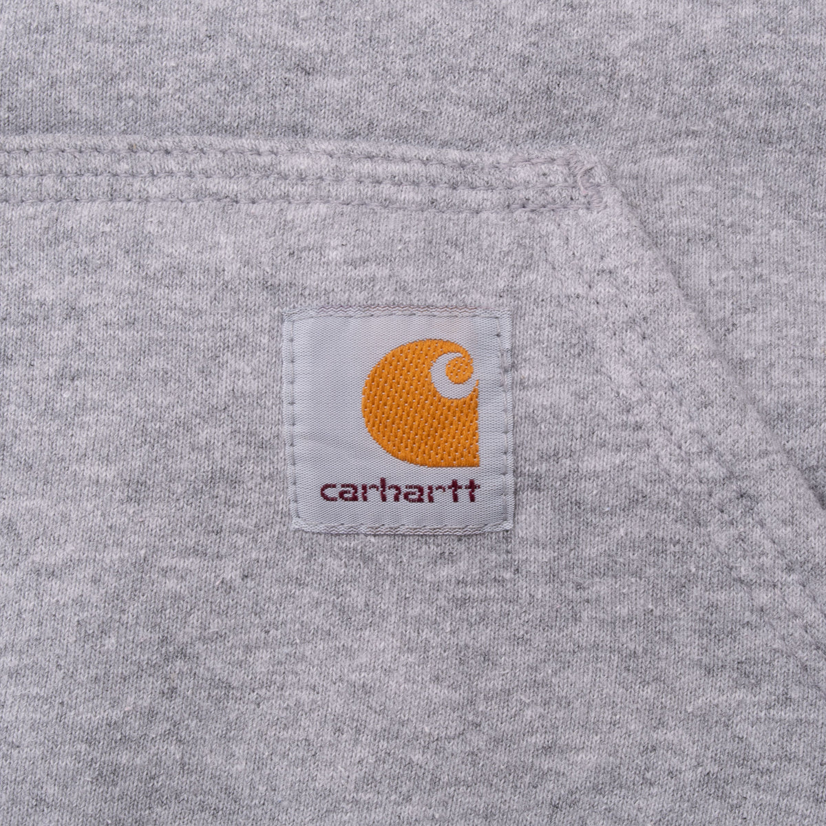 Carhartt logo patch detail on grey hoodie kangaroo pocket