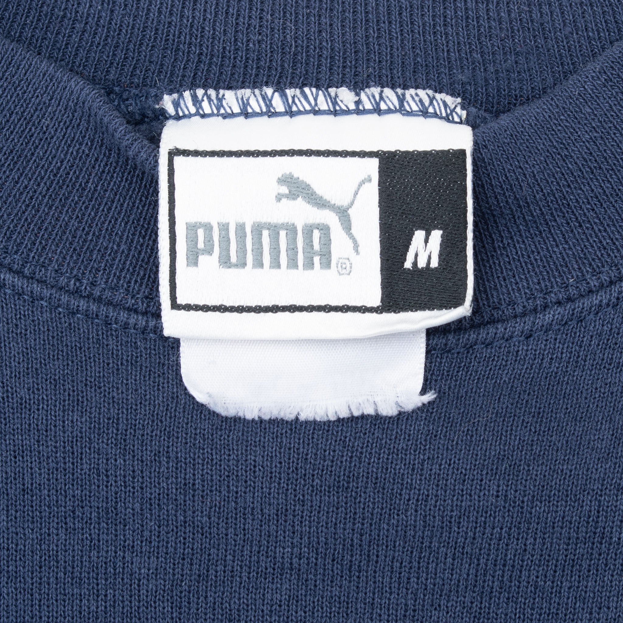 Close-up of Puma medium neck tag inside navy sweatshirt