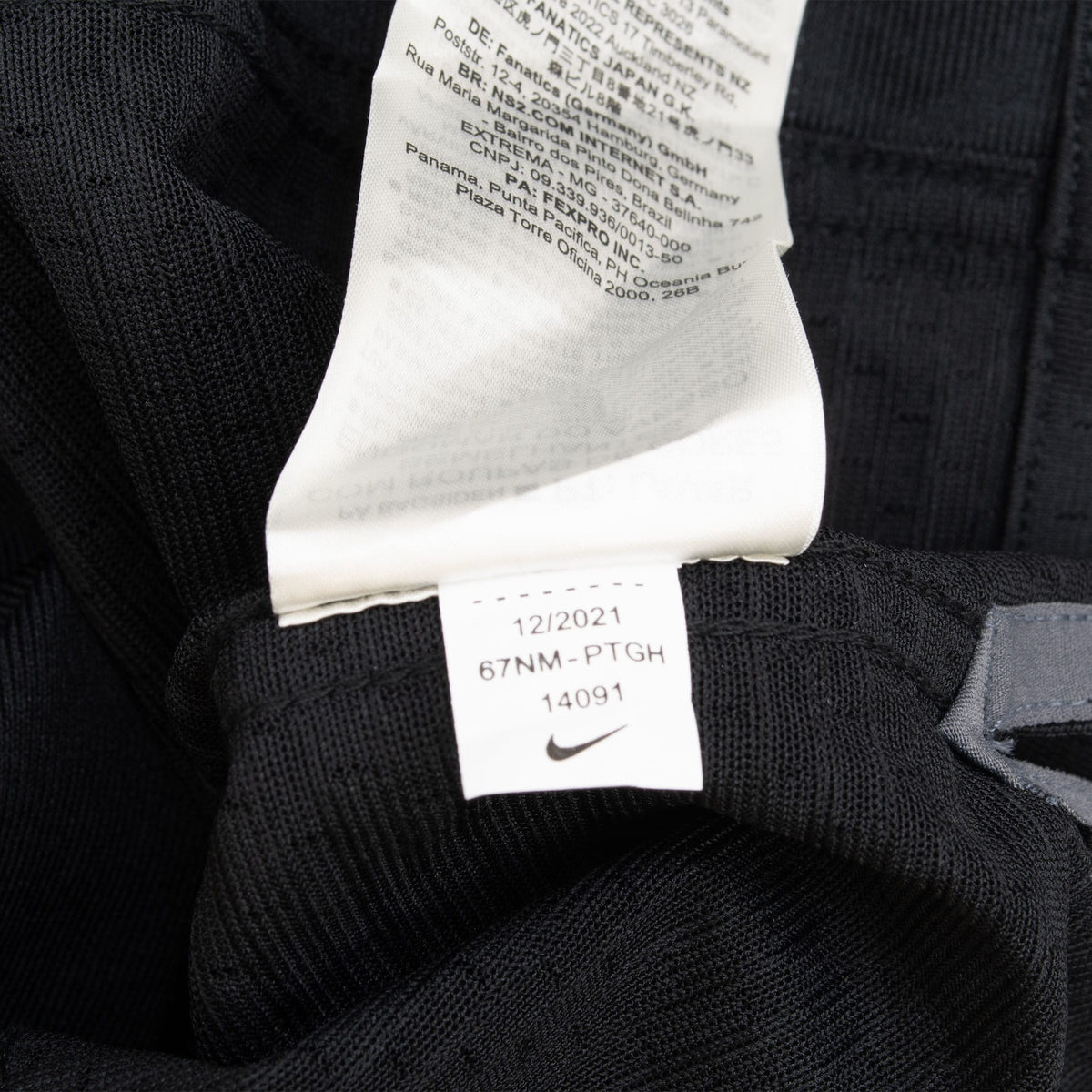 Close-up of interior care and production tags on black Nike jersey