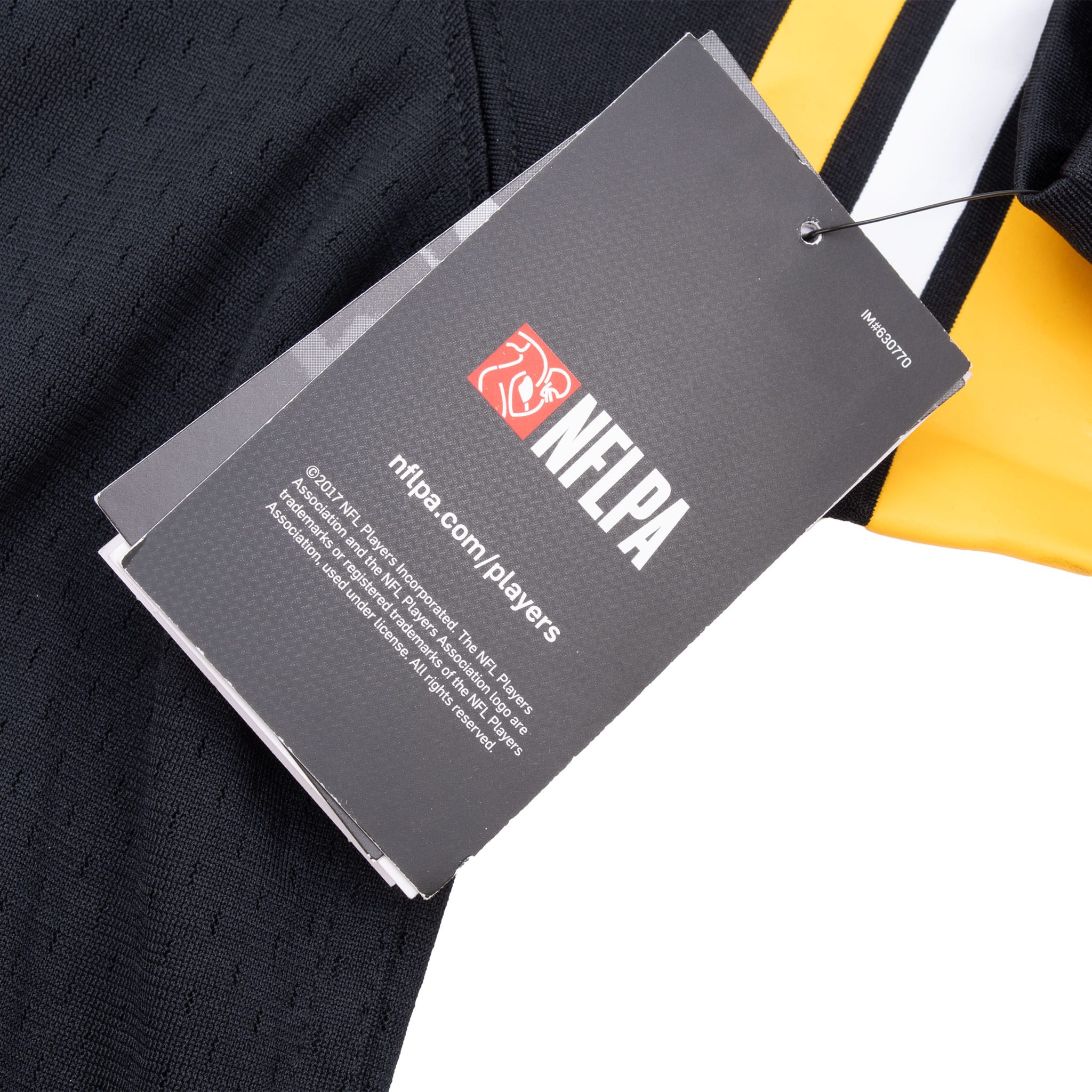 Attached NFL Players Association hangtag beside the jersey's gold-and-white sleeve stripes