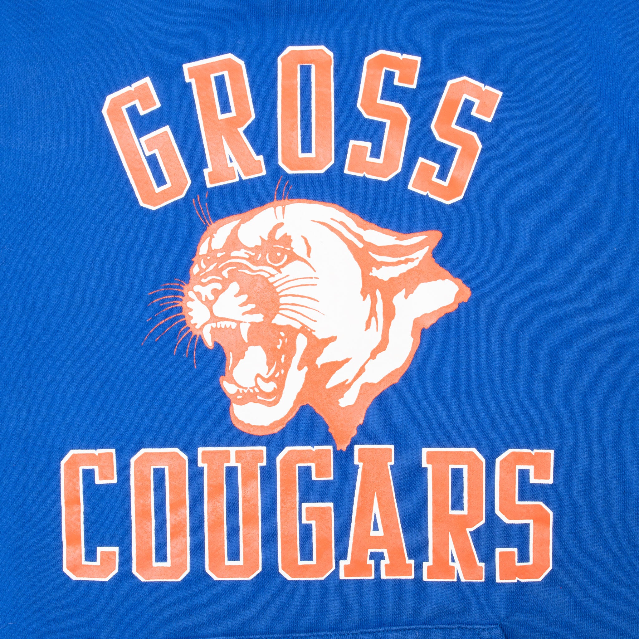 Close-up of orange and white Gross Cougars lettering and cougar graphic on blue hoodie