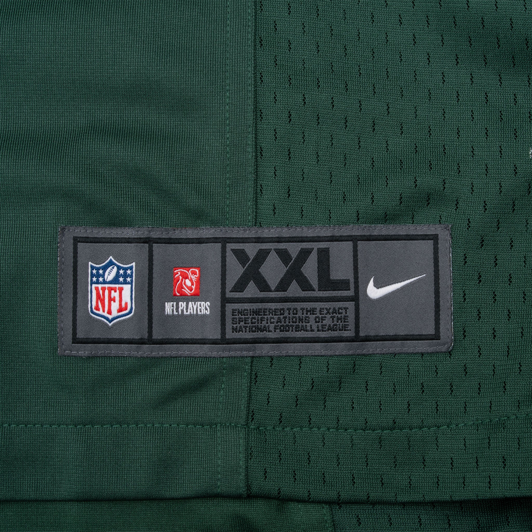 Lower hem detail with Nike NFL Players XXL jock tag on green mesh fabric