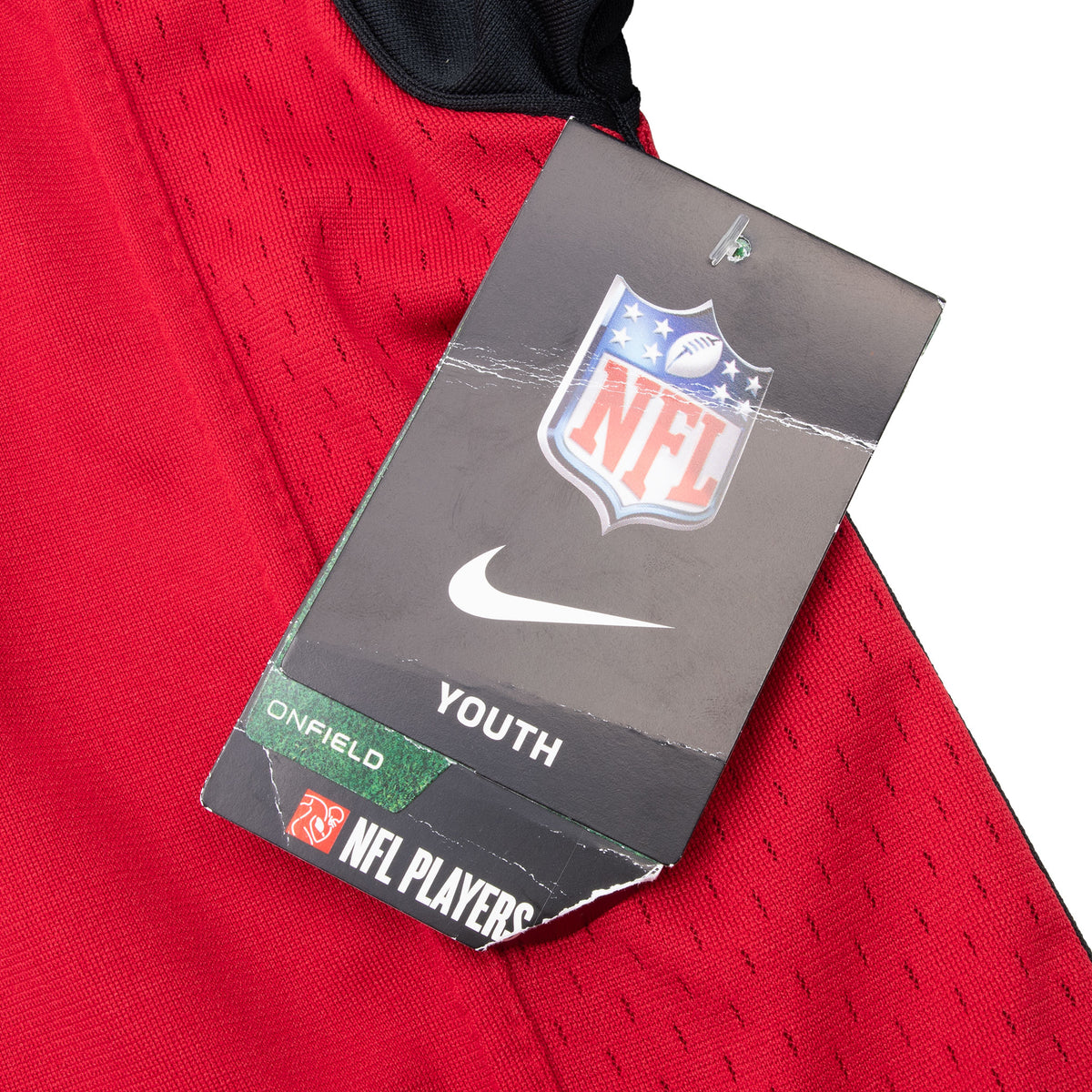 Close-up of attached Nike NFL Youth On Field hangtag on red jersey