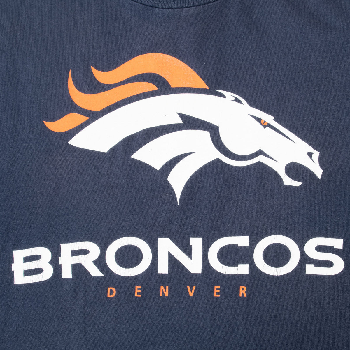 Close-up of Denver Broncos horse logo and lettering on navy T-shirt